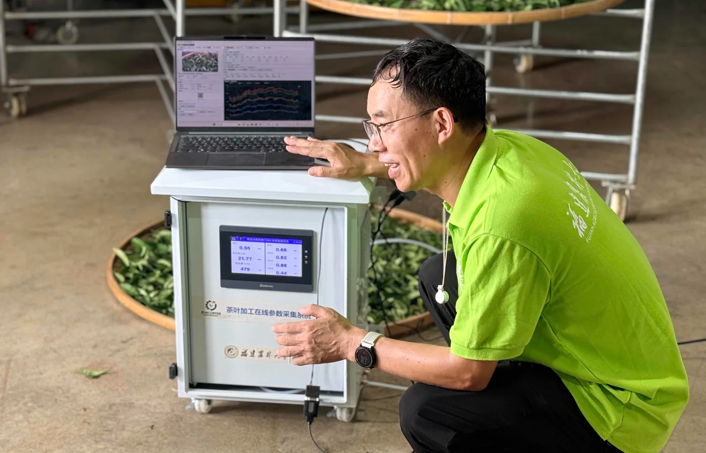 Xiao Chaohu demonstrating the tea processing data collection system at a production site